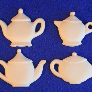 May include: Four white ceramic teapots with different shapes and sizes. The teapots are on a blue background.