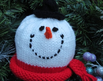 Puede incluir: Adorno de muñeco de nieve tejido con cabeza blanca, sombrero negro y bufanda roja. El muñeco de nieve tiene una sonrisa negra cosida, ojos y una nariz de zanahoria naranja. Ideal para decoraciones navideñas o invernales.