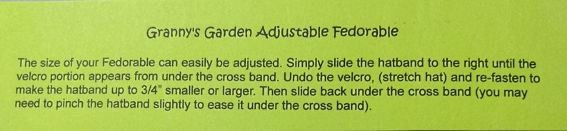 Peut inclure: Une carte d'instructions verte pour ajuster la taille d'un "Granny's Garden Adjustable Fedorable". Le texte explique comment ajuster le bandeau en le faisant glisser vers la droite jusqu'&agrave; ce que la partie velcro apparaisse, puis en d&eacute;faisant le velcro et en le refermant pour rendre le bandeau jusqu'&agrave; 1,9 cm plus petit ou plus grand.