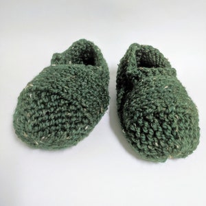 May include: A pair of green knitted slippers with a textured surface.
