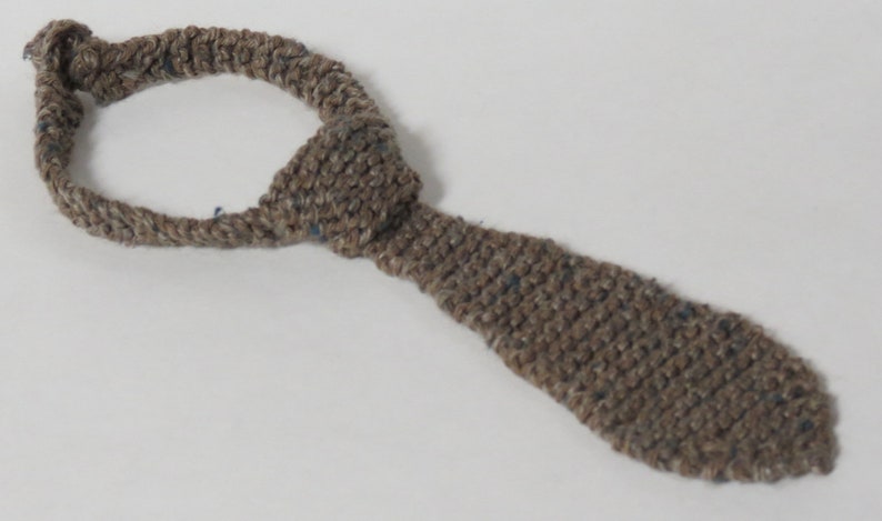Peut inclure: Une cravate en crochet marron avec un n&oelig;ud en haut.