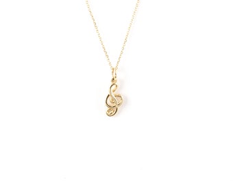 May include: A gold chain necklace with a treble clef pendant.