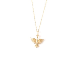 May include: A gold necklace with a delicate bird pendant. The bird has a detailed design with small, round accents.