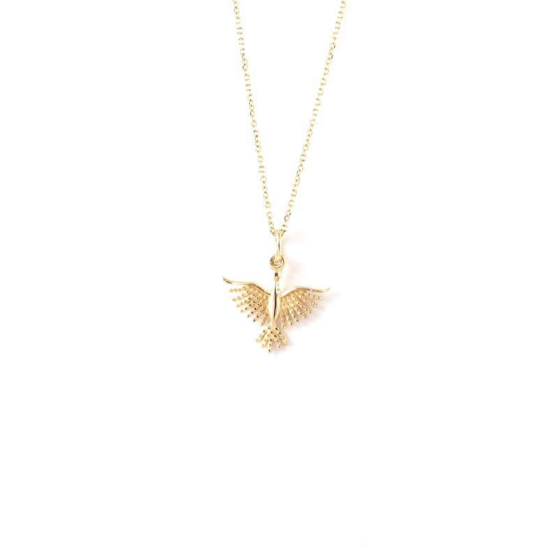 May include: A gold necklace with a delicate bird pendant. The bird has a detailed design with small, round accents.