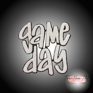 May include: White felt applique with the words "game day" in a stylized font. The applique is on a black background.