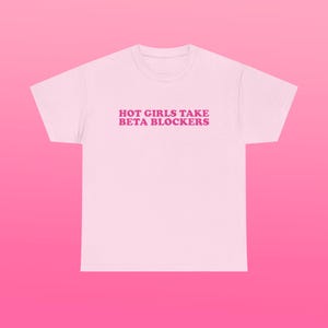 May include: Pink t-shirt with the text "HOT GIRLS TAKE BETA BLOCKERS" printed in pink.