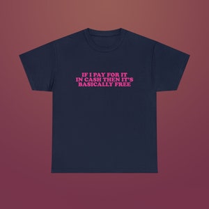 Puede incluir: Una camiseta azul marino con el texto "IF I PAY FOR IT IN CASH THEN IT'S BASICALLY FREE" impreso en rosa.