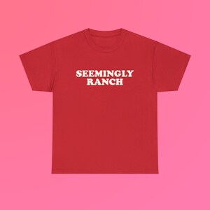 May include: Red t-shirt with white text that reads "SEEMINGLY RANCH"