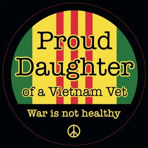 May include: A yellow, red, and green circle with the text "Proud Daughter of a Vietnam Vet" and "War is not healthy" with a peace sign below the text.