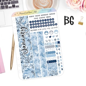 May include: A planner sticker sheet with a winter theme. The sheet features blue and white designs, including floral patterns, snowflakes, and date stickers. Text includes "January", "First Snow January", and "Mama Cass Plans".