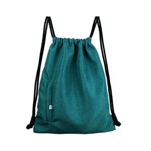 Peut inclure: Un sac à cordon de couleur turquoise avec des cordons noirs et une petite poche sur le devant.
