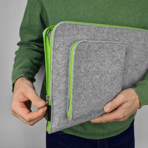 Man opens flet sleeve with green zipper.