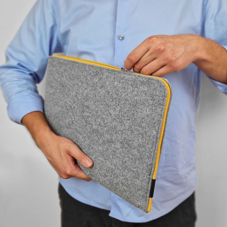 Men holding light grey felt laptop sleeve with yellow zipper. Cover opens on the side and top. Hand made felt case will fit your laptop easly. All sizes avaliable - 13 inch, 15 inch and other.