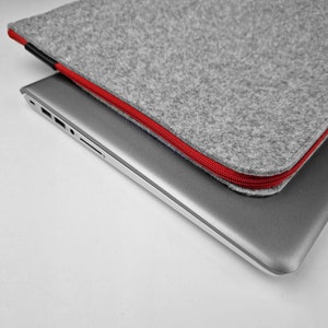 Zoom on the red zipper, light grey felt laptop cover.
