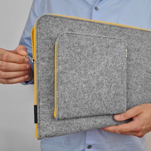 Front pocket for wires, mouse, etc. Laptop felt case with yellow zipper. Pocket firmly attached to the main part of the sleeve. Silver zipper holder.