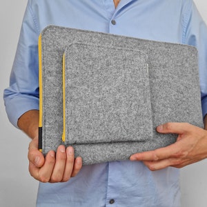 Men holding light grey felt laptop sleeve with yellow zipper and front pocket for wires. We make all sleeves to order - every size is possible.