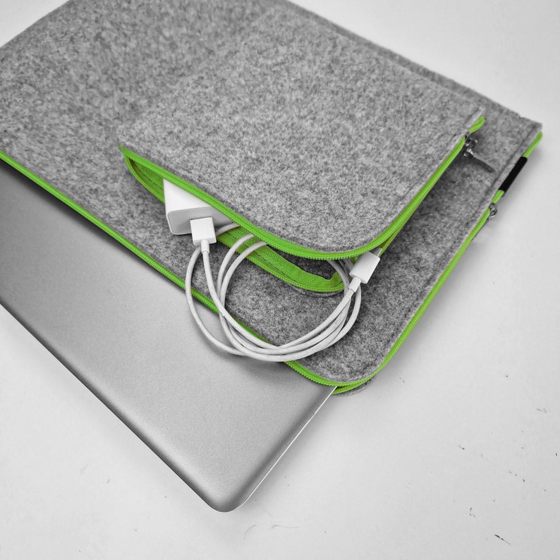 Light grey felt laptop sleeve with green zipper. Front pocket for wires sewn on the case.