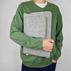 Man holding light grey felt laptop sleeve closed. Front pocket for charger.