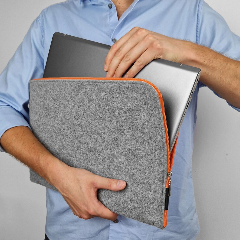Felt laptop case with orange zipper. Men opens the case and take 15 inch laptop out. Custom made felt cover to fit your laptop, every size avaliable.