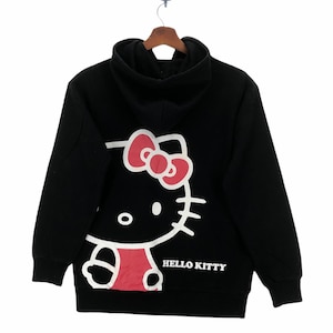 May include: Black hooded sweatshirt with a white Hello Kitty graphic on the back. The graphic features Hello Kitty with a pink bow and a red dress.