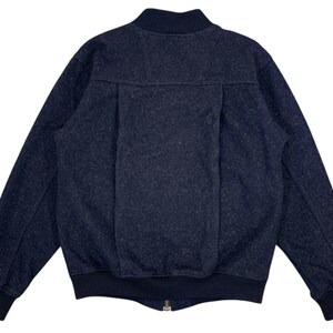 Puede incluir: Chaqueta bomber azul marino oscuro con tejido texturizado. La chaqueta tiene cuello, pu&ntilde;os y dobladillo de canal&eacute;, y cierre de cremallera frontal. La parte trasera de la chaqueta tiene un detalle de costura vertical.