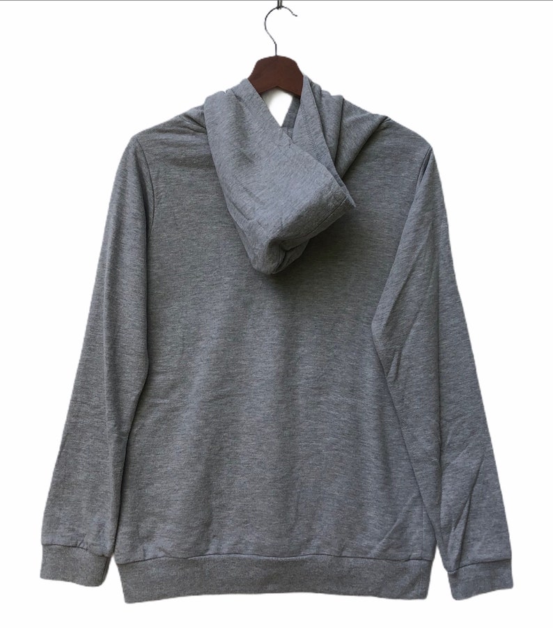 May include: A gray hooded sweatshirt with a zipper closure. The hoodie is folded down and the sweatshirt is hanging on a wooden hanger.