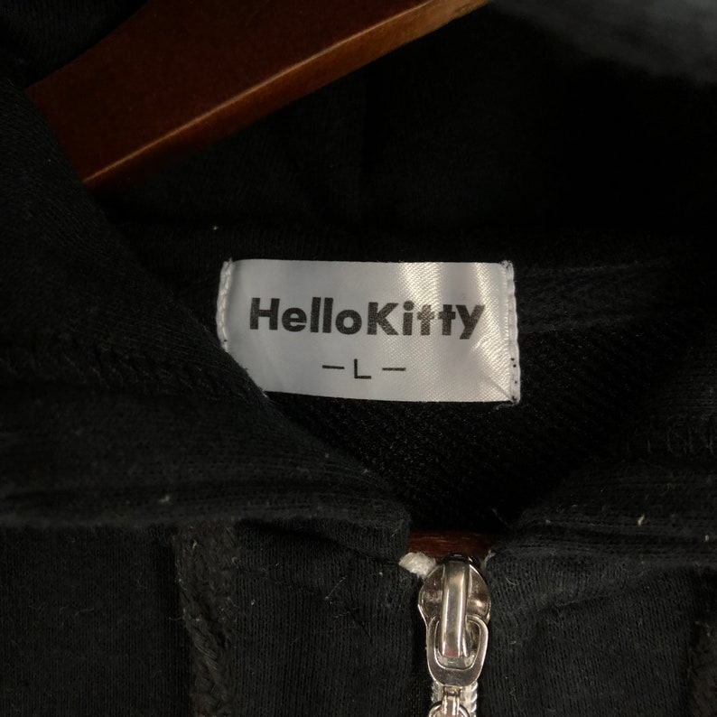 May include: Black zippered hoodie with a Hello Kitty label and the size "L" written on it.