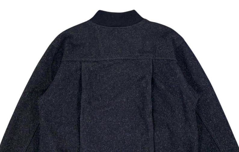 Puede incluir: Chaqueta bomber gris oscuro con cuello de canal&eacute;. La chaqueta tiene un aspecto texturizado y un dise&ntilde;o sencillo y cl&aacute;sico. La parte trasera de la chaqueta presenta un detalle de costura vertical.