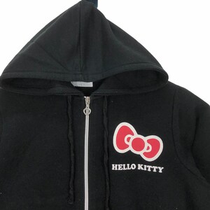 May include: Black zip-up hoodie with a red Hello Kitty bow and the text "HELLO KITTY" in white.