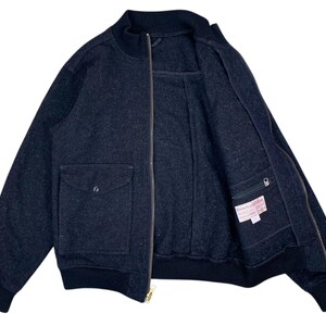 Puede incluir: Chaqueta bomber gris oscuro con cierre de cremallera completo y dos bolsillos delanteros. La chaqueta tiene cuello, pu&ntilde;os y dobladillo de canal&eacute;. El forro interior es visible y una peque&ntilde;a etiqueta est&aacute; cosida en el interior.