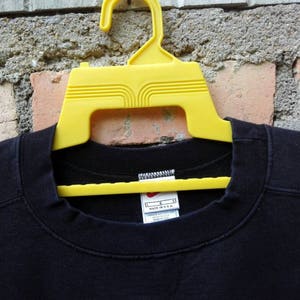 May include: Black crew neck t-shirt with a white tag that reads "L" and "Made in U.S.A."