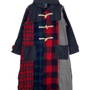 May include: A patchwork coat with a hood, featuring a mix of red plaid, navy, and gray fabrics. The coat has toggle closures and two front pockets. The sleeves and hood are a solid gray color.