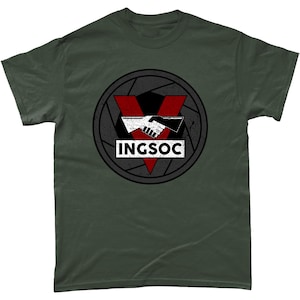 May include: A dark green t-shirt with a distressed black and white circle graphic. The graphic features a red triangle with a handshake inside and the text "INGSOC" in white.