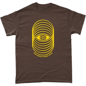 May include: A brown t-shirt with a yellow graphic of an eye with concentric circles around it. The text "MAKE ORWELL FICTION AGAIN" is printed below the graphic.