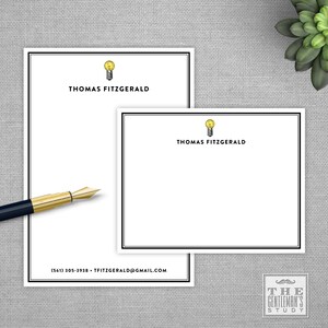 May include: White stationery with a black border and a light bulb graphic. The text "THOMAS FITZGERALD" is printed in black at the top of the stationery. The text "(561) 305-3938 - TFITZGERALD@GMAIL.COM" is printed in black at the bottom of the stationery. The text "THE GENTLEMAN'S STUDY" is printed in black at the bottom right corner of the stationery.
