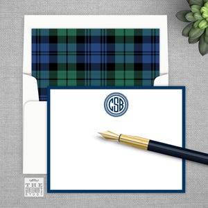 May include: A white card with a blue border and a blue and green plaid pattern on the envelope. The card has a monogram in a circle with the letters "CSB" in navy blue. The text "THE GENTLEMAN'S STUDY" is at the bottom of the card.