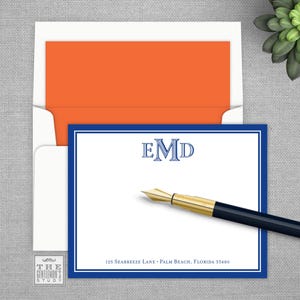 May include: A white card with a blue border and a blue monogram "EMD" in the center. The card has a white background and a blue border. The address "125 Seabreeze Lane - Palm Beach, Florida 33480" is printed at the bottom of the card.