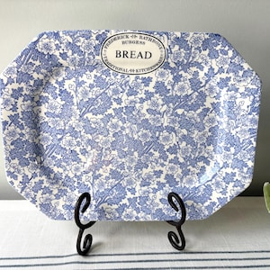 May include: An octagonal ceramic bread tray featuring a blue and white floral pattern. The center top includes a white oval label with the text Frederick Rathbone Burgess BREAD TRADITIONAL KITCHENWARE printed in black lettering.