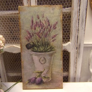 Peut inclure: Une impression de style vintage d'une plante de lavande dans un pot blanc sur un fond rustique. L'impression est encadrée et prête à être accrochée.