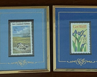 May include: Two framed postage stamps. The left stamp features a badger on a grassy field with the text "Save Grassland Habitats" and "USA 18c". The right stamp features a purple iris with the text "Get Well!" and "USA 22".