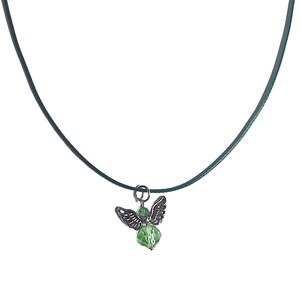 Puede incluir: Un collar con un colgante de &aacute;ngel de cristal verde en un cord&oacute;n verde oscuro.