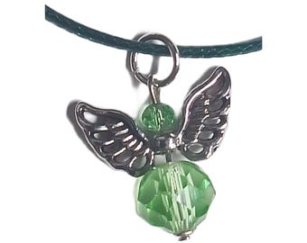 May include: A silver angel charm with green crystal wings and a green crystal body. The charm is attached to a black cord.