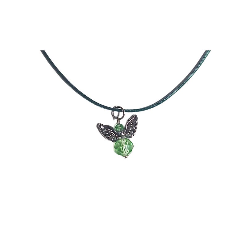 Puede incluir: Un collar con un colgante de &aacute;ngel de cristal verde en un cord&oacute;n verde oscuro.