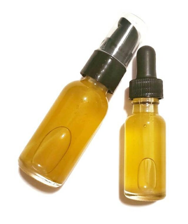 May include: Two glass bottles with amber liquid. The larger bottle has a black pump top and the smaller bottle has a black dropper top.
