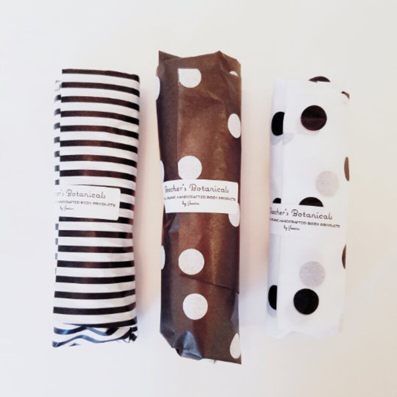 May include: Three gift-wrapped packages with brown, white, and black polka dot paper. Each package has a label that reads "Beecher's Botanical Organic Handcrafted Body Products by Jessica."