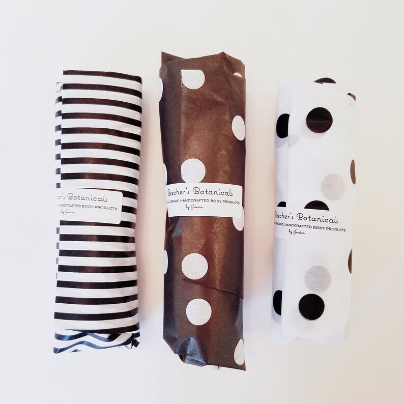 May include: Three rolls of brown and white patterned wrapping paper with black and white stripes, white polka dots, and black and white polka dots. Each roll has a label that reads "Bacher's Botanicals Organic Handcrafted Body Products by Janine."