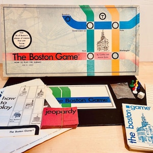 May include: The Boston Game board game with a subway map design. Includes game pieces, instructions, and a Jeopardy card set. The box features the text "How to Play the Subway" and "Visit 36 of Boston's places of interest."