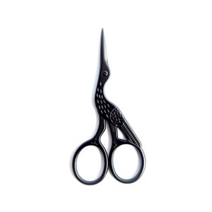 May include: Black crane-shaped embroidery scissors. The scissors have a bird-like design with a long, pointed beak and a decorative pattern on the body. The handles are circular, and the blades are sharp and pointed.