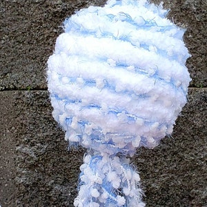 May include: A white and light blue fluffy yarn ball with a long, fluffy tail. The yarn ball is made of a soft, fuzzy material and has a light blue and white striped pattern.