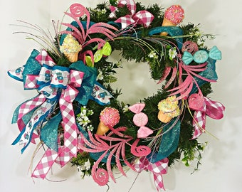 May include: A pink and teal wreath decorated with ice cream cones, candy, and a pink and white gingham bow.